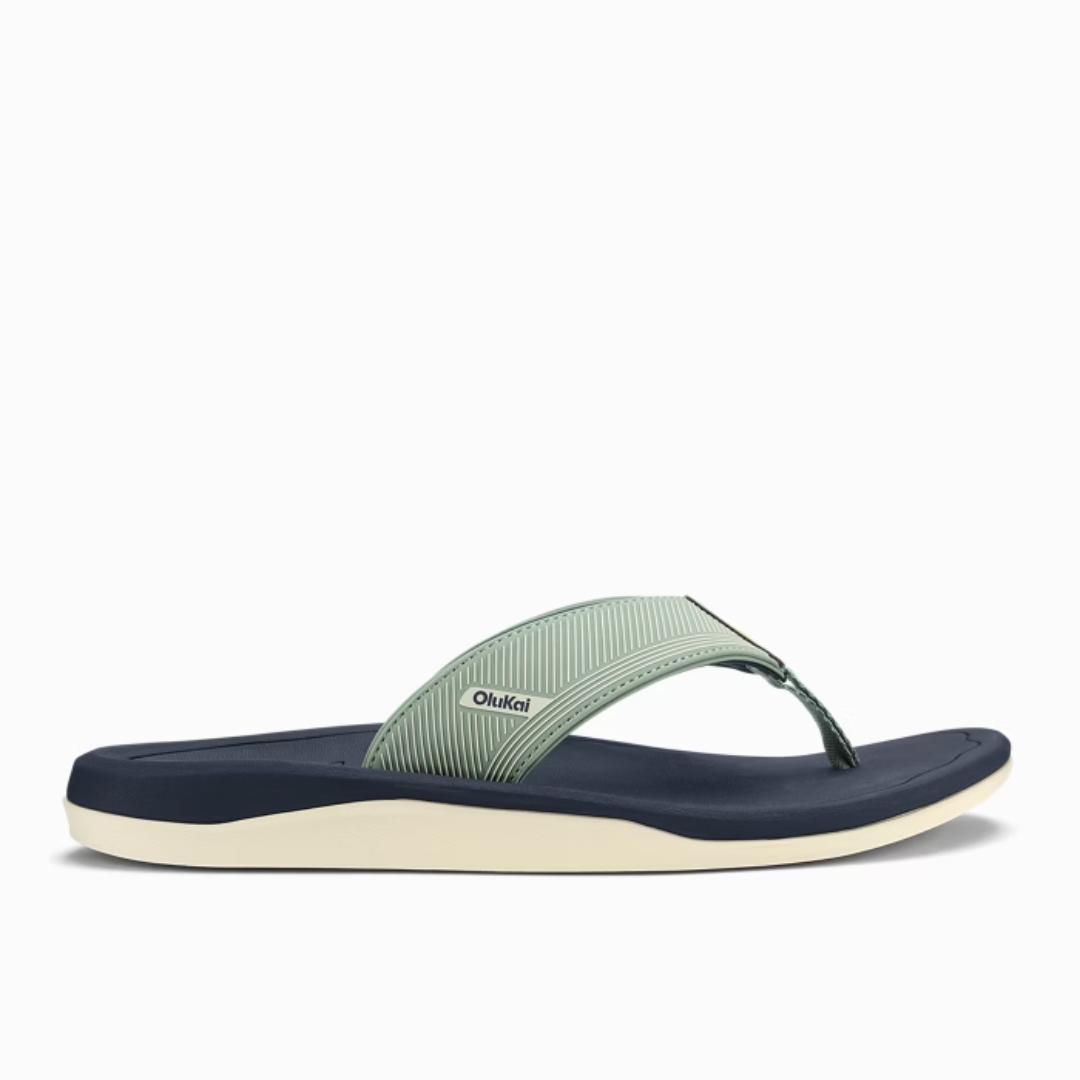 Green and navy sandal with 'OluKai' branding on a white background