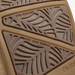 Close-up of a brown rubber shoe sole showing textured sections labeled 'NON-MARKING' and 'WET GRIP RUBBER' with a leaf-like tread pattern.