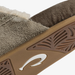 Close-up of a slip-on shoe or mule showing the textured taupe-brown suede upper, white fuzzy trim, and a tan sole with a white stylized logo.