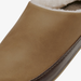 Close-up of a slip-on mule shoe in tan suede with a dark brown trim and white shearling lining.