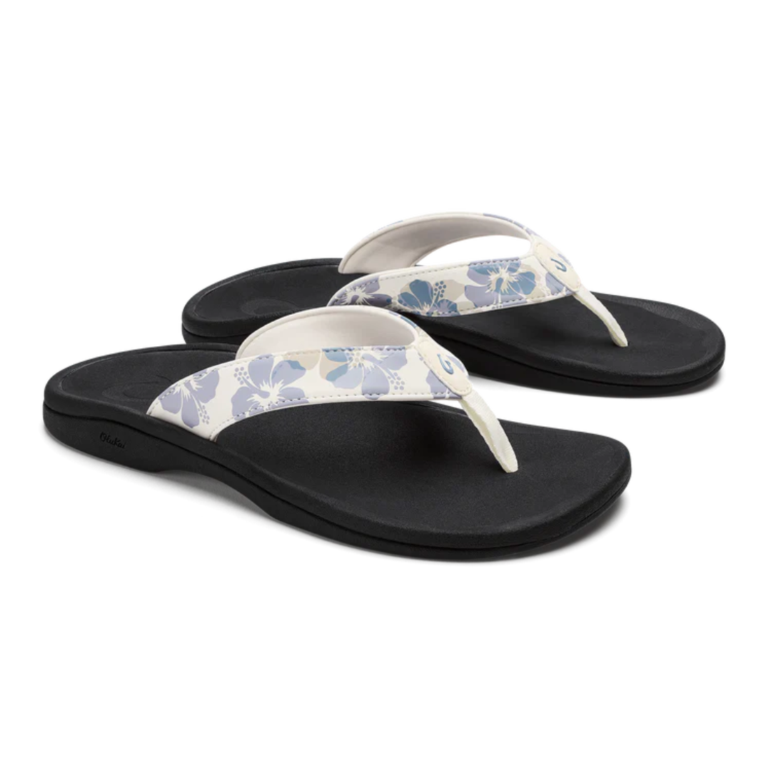 Pair of black sandals with floral straps on a white background