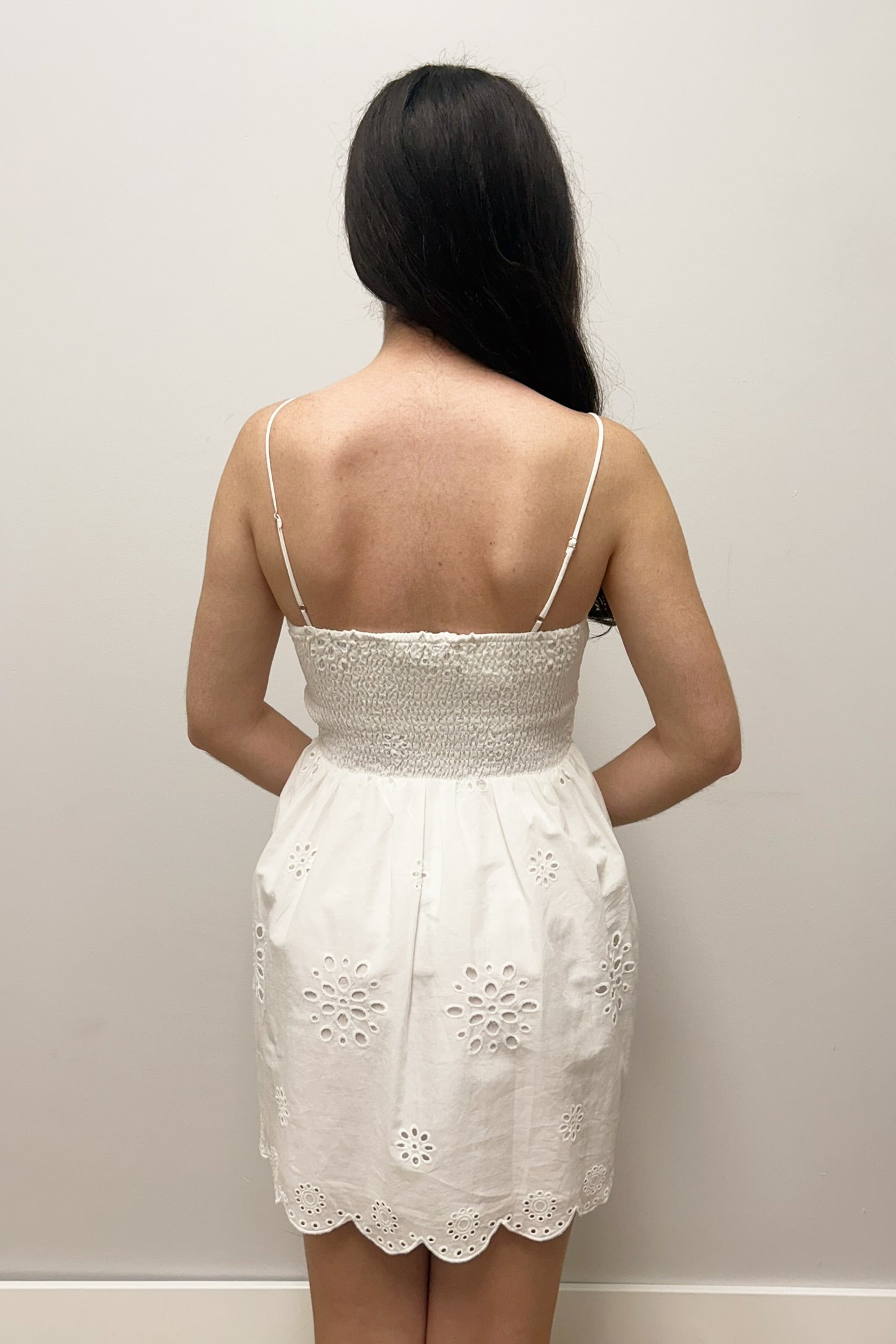 Woman wearing white dress with eyelet detail