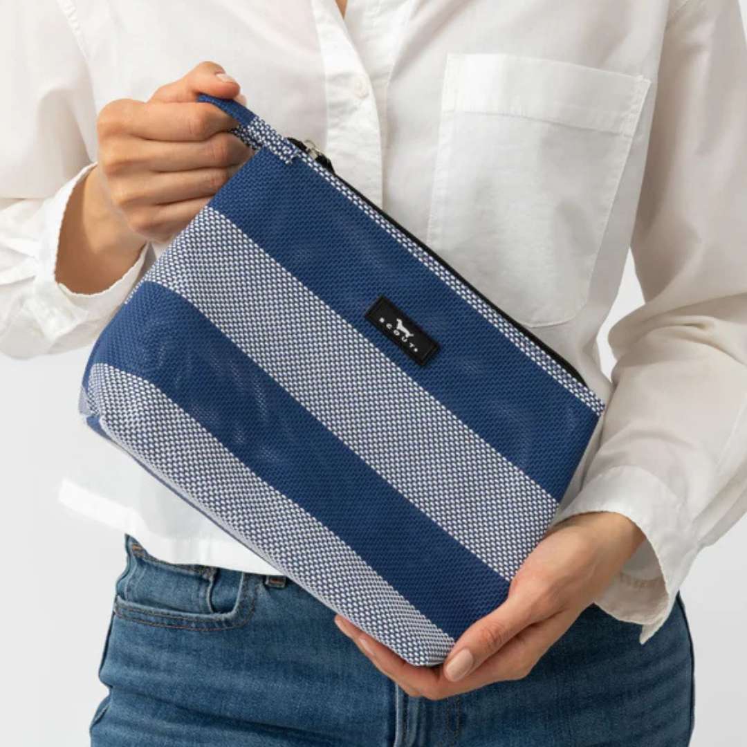 Person holding a blue and white striped pouch with a visible brand logo.