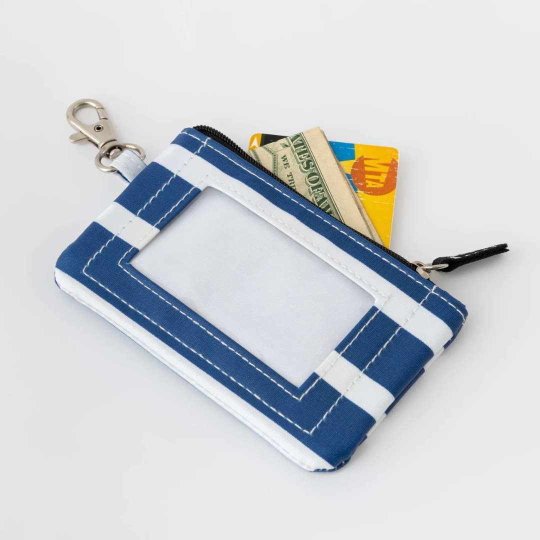 Blue and white pouch with a keychain, containing money and cards, on a light gray background
