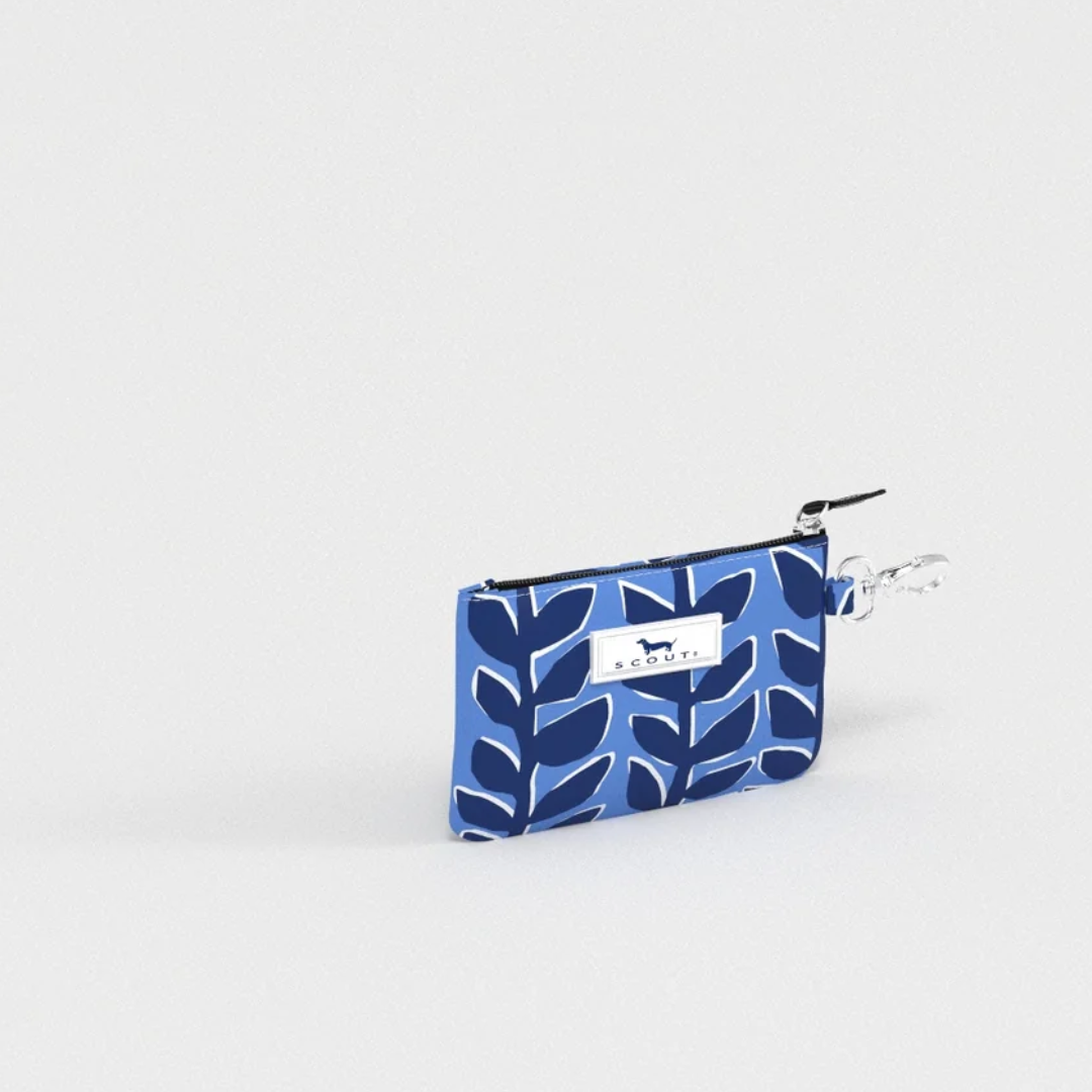 A small zip pouch with a blue and navy leaf pattern, featuring a white brand label that reads 'BLOOM' with a dog silhouette, and a silver metal clip attachment.