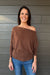 Woman wearing Six Fifty Anywhere Top In Chestnut with jeans on a dark wood background.