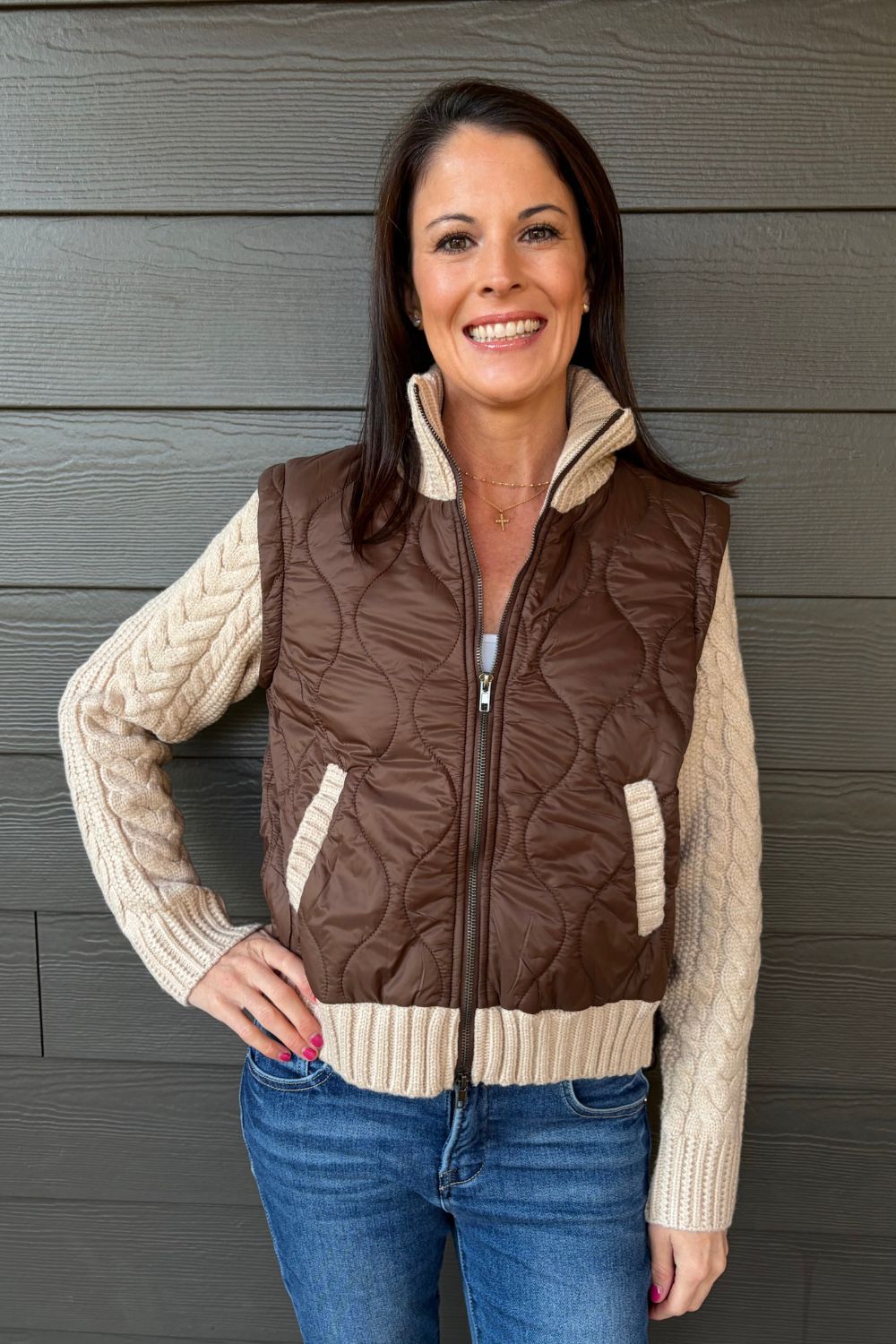 Woman wearing Six Fifty Melanie Mixed Media Jacket In Brown with jeans on a dark wood background.