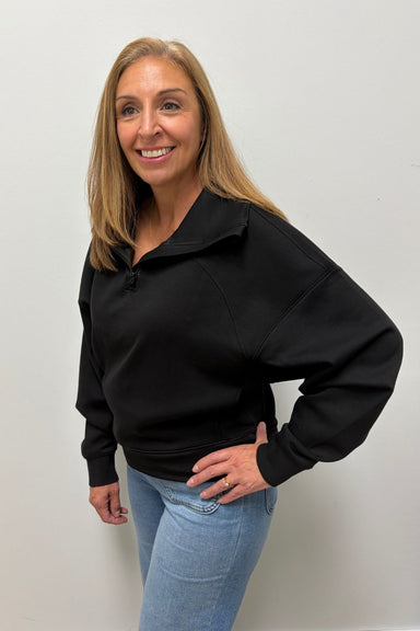 Woman wearing Six Fifty Scuba 1/4 Zip In Black with blue jeans on a plain white background.