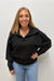 Woman wearing Six Fifty Scuba 1/4 Zip In Black with blue jeans on a plain white background.