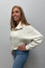 Woman wearing Six Fifty Scuba 1/4 Zip In Cream with blue jeans on a plain white background.