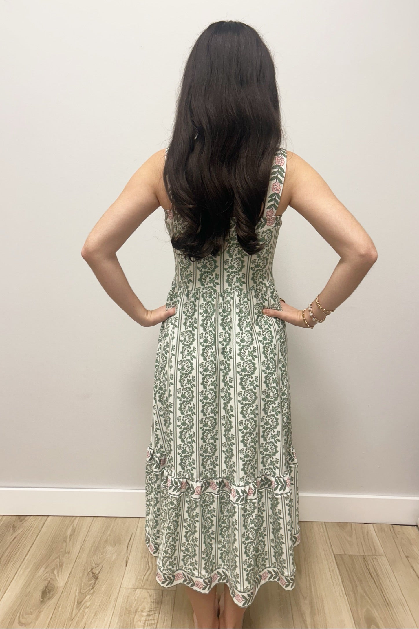 Woman wearing white dress with green floral pattern