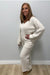 Woman wearing Softies Cable Knit Marshmallow V-Neck with Flared Sleeve and Pant Almond on a plain white background.
