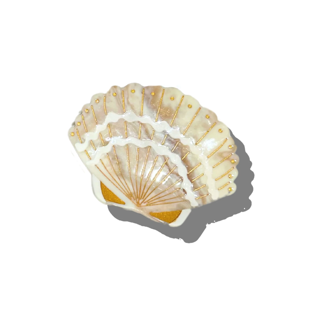Decorative shell with gold accents on a white background