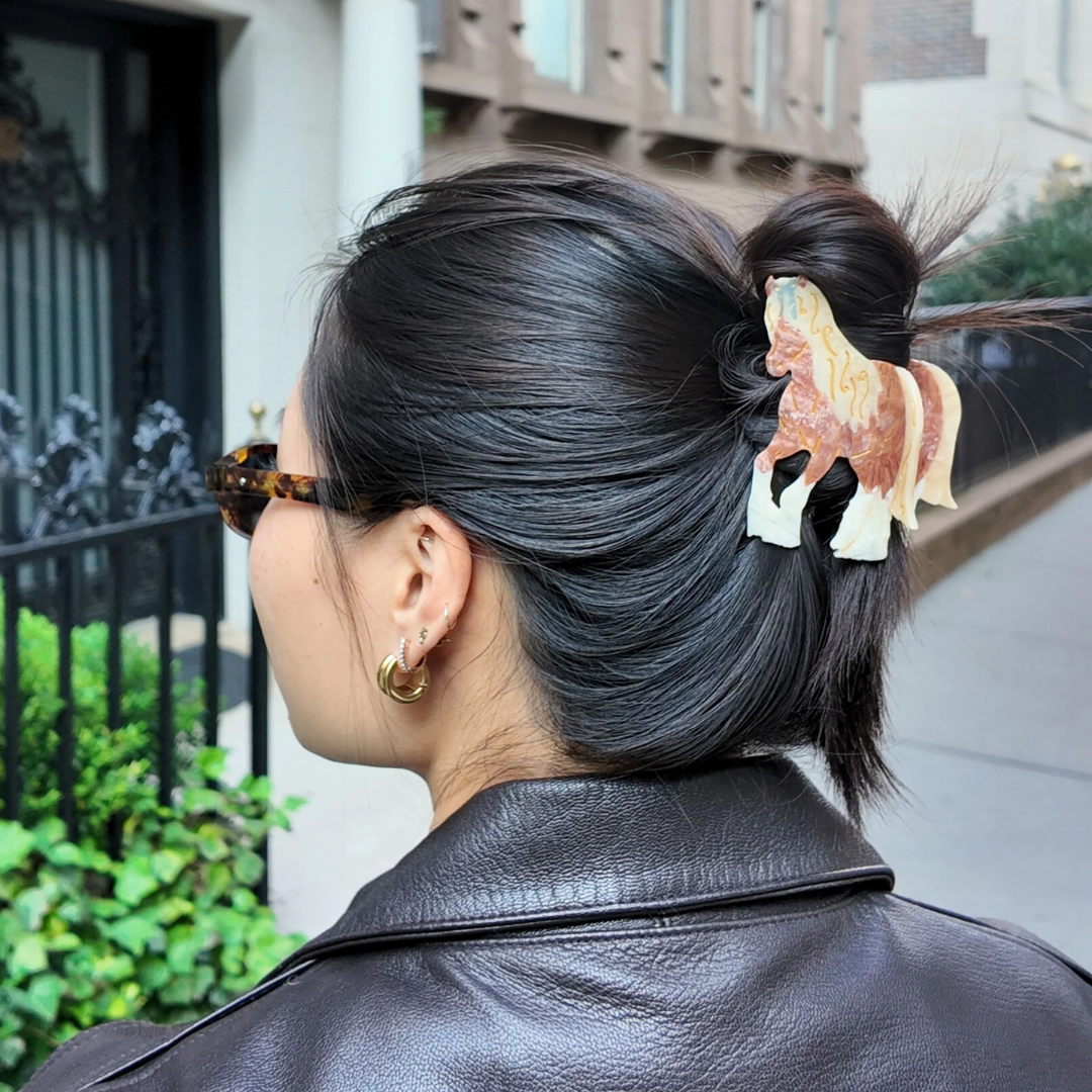 Person with a hair accessory shaped like a horse in an urban setting