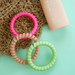 hair ties with other items against mint green background