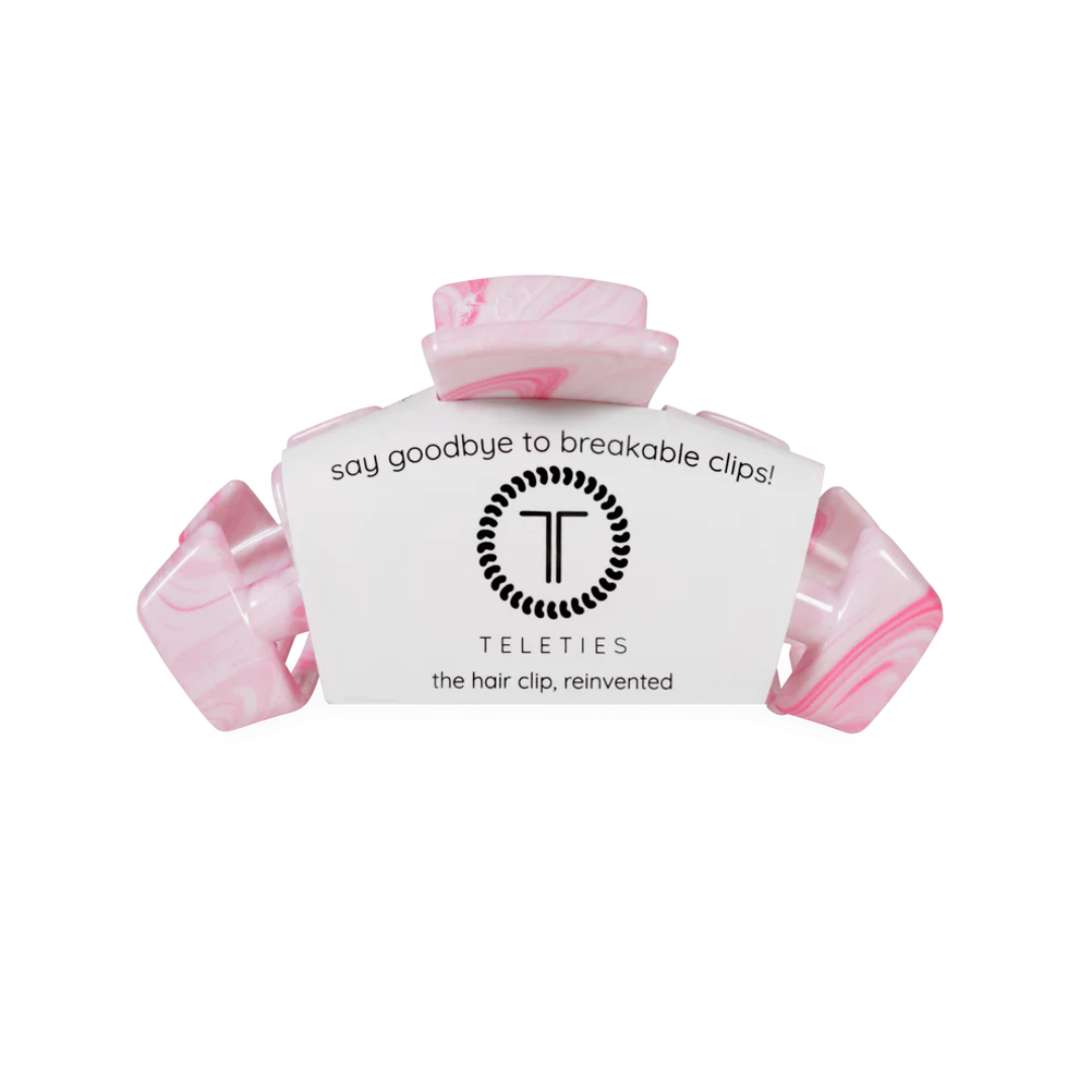Pink hair clip with white label on a white background