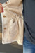 Woman wearing Very Moda Fur Snap Vest In White with jeans on a dark wood background.