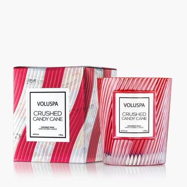 Voluspa Crushed Candy Cane coconut wax candle shown with its matching outer box and glass jar, featuring a red and white striped candy cane pattern on a clean white background.