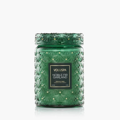 A green textured glass jar candle with a matching lid, featuring a black label that reads 'VOLUSPA NOBLE FIR GARLAND' on a clean white background.