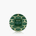A round green and gold patterned tin of VOLUSPA Noble Fir Garland coconut wax, centered on a light gray background with a soft reflection below.