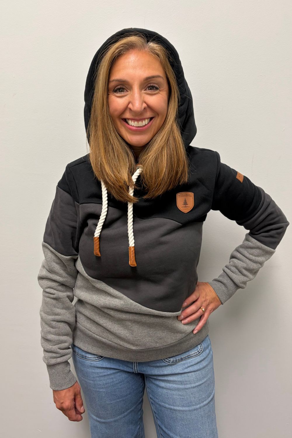 Woman wearing Wanakome Selene Hoodie In Black Carbon Mix on a plain white background.