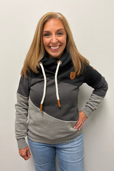 Woman wearing Wanakome Selene Hoodie In Black Carbon Mix on a plain white background. 