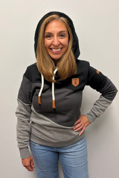 Woman wearing Wanakome Selene Hoodie In Black Carbon Mix on a plain white background.