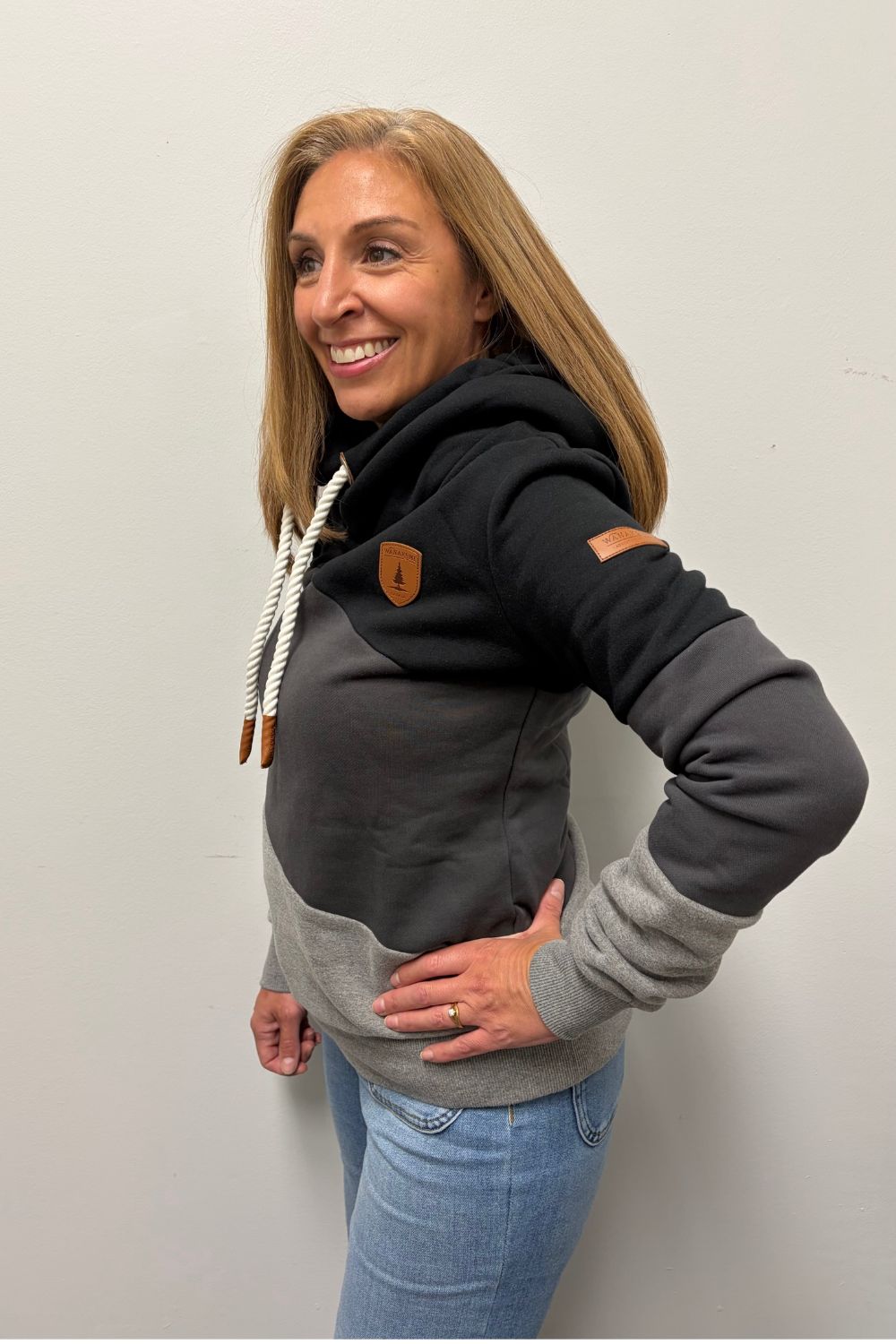 Woman wearing Wanakome Selene Hoodie In Black Carbon Mix on a plain white background.