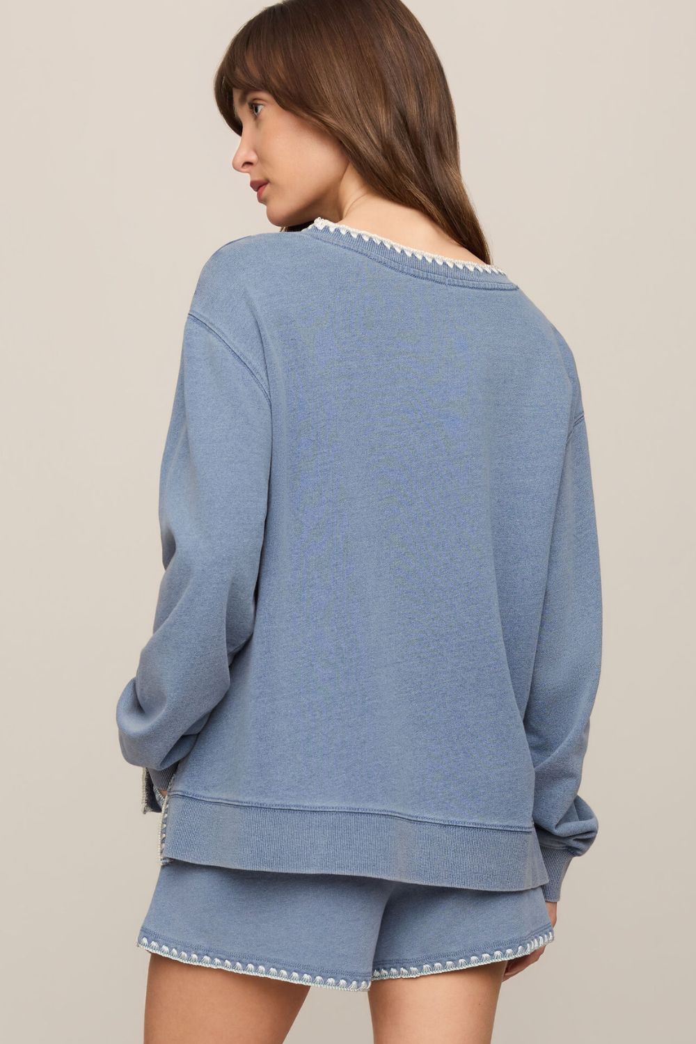 woman wearing a blue sweater on a white background