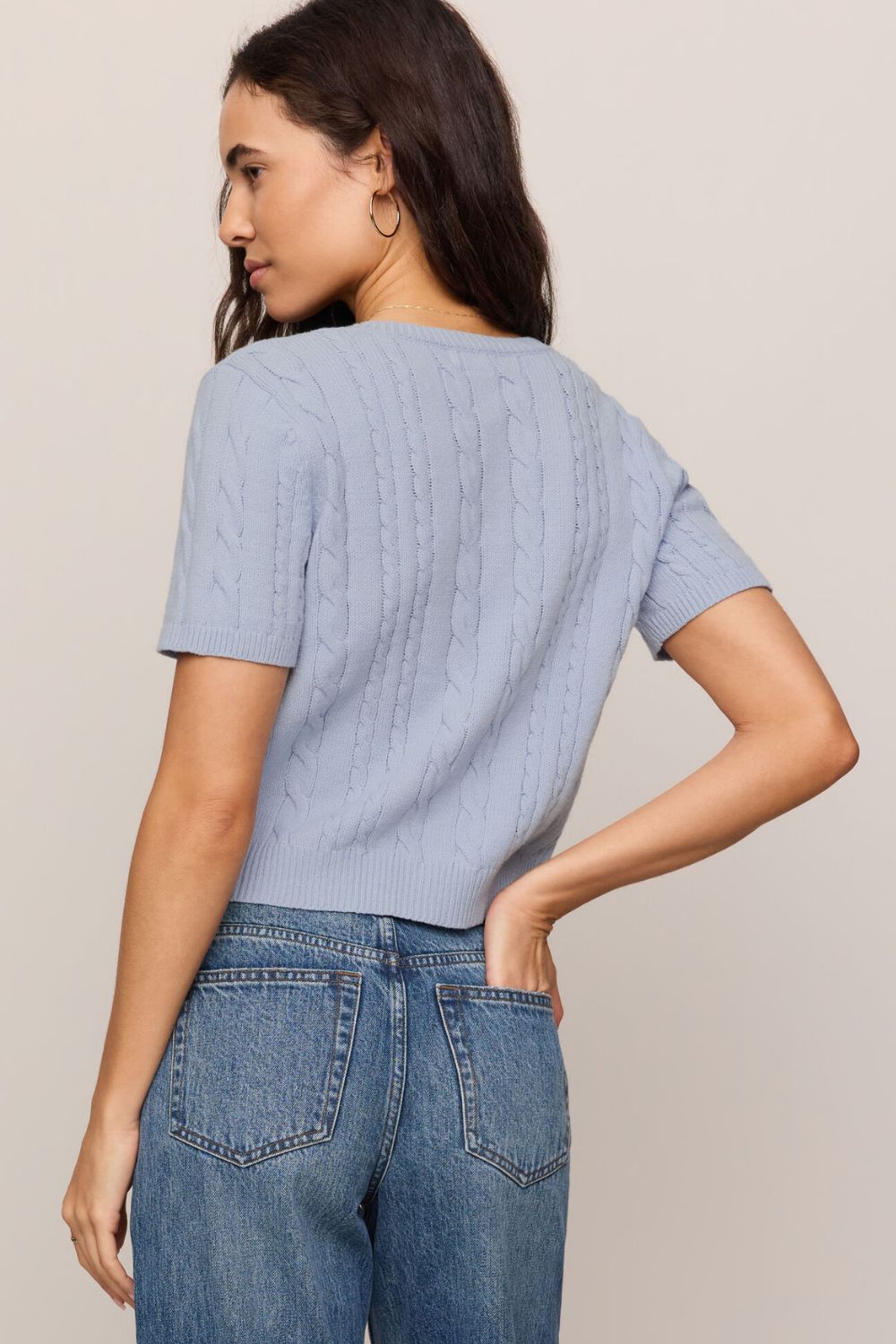 woman wearing blue sweater on a white background
