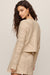 woman wearing tan textured set with a white background