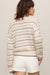 woman wearing tan striped sweater on a white background
