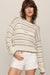 woman wearing tan striped sweater on a white background