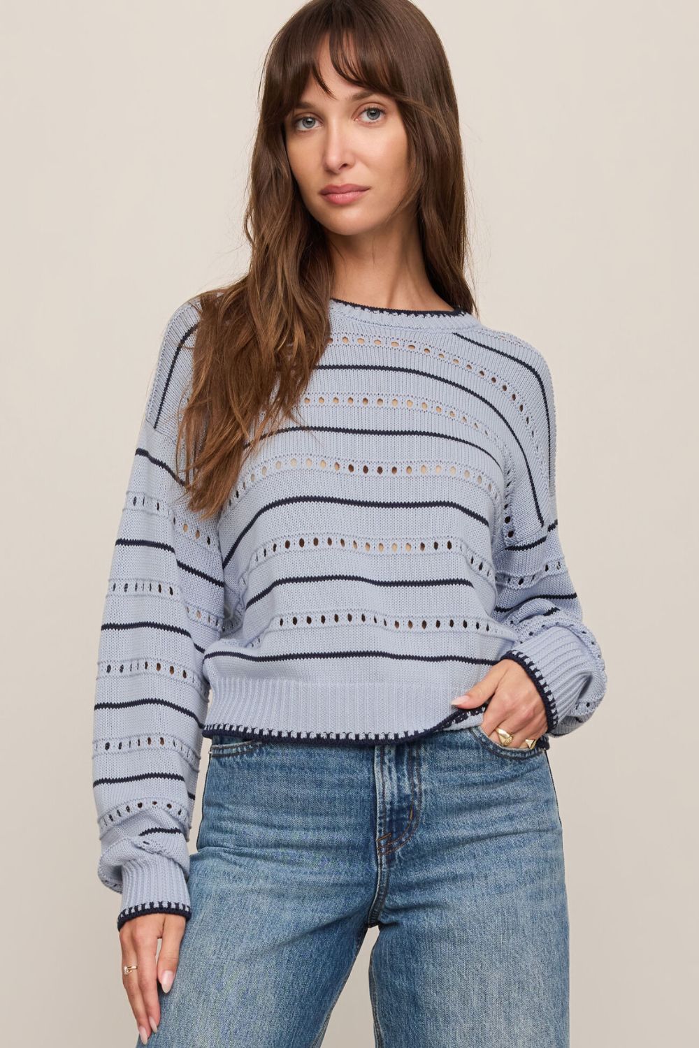 woman wearing striped blue sweater on a white background
