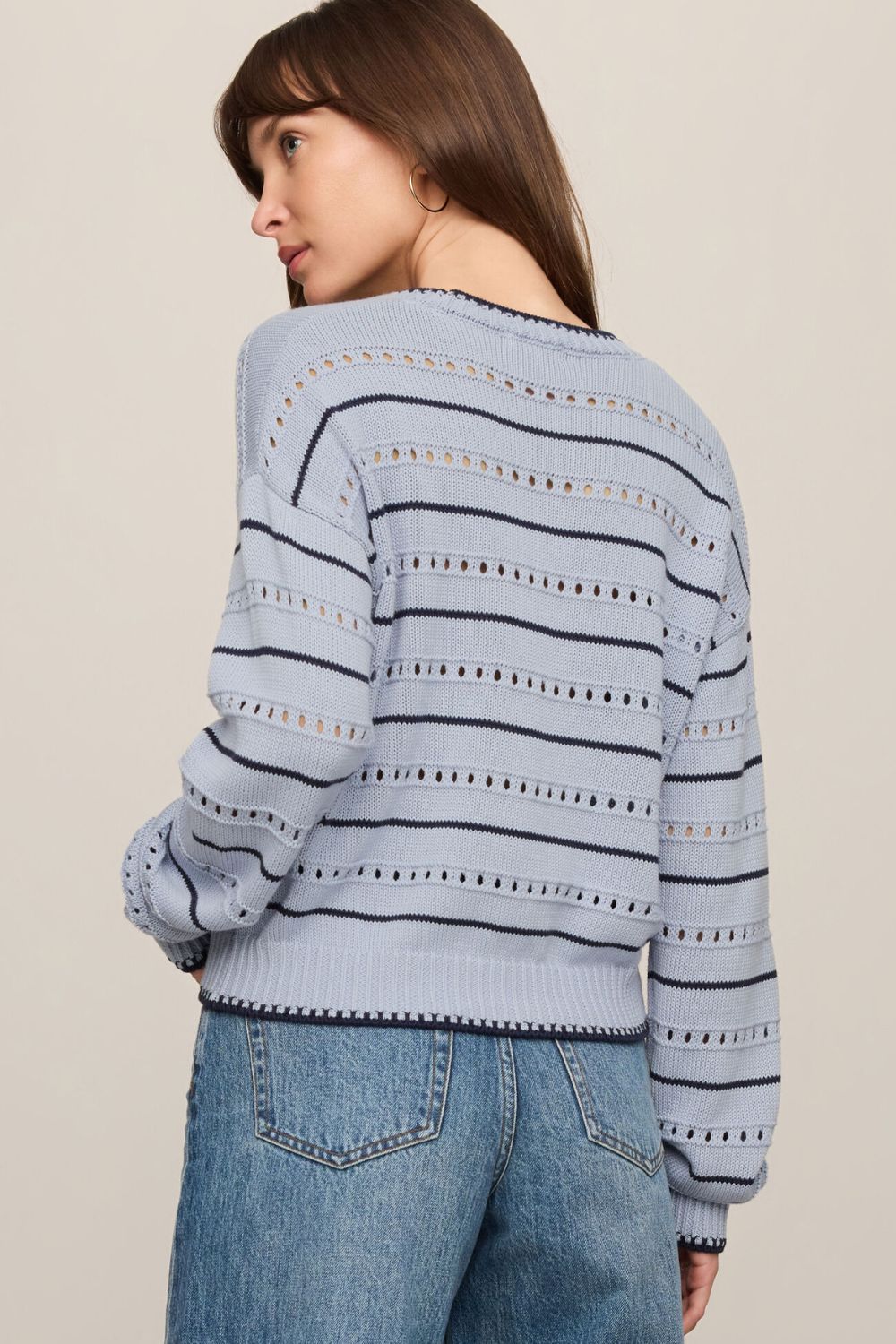 woman wearing striped blue sweater on a white background