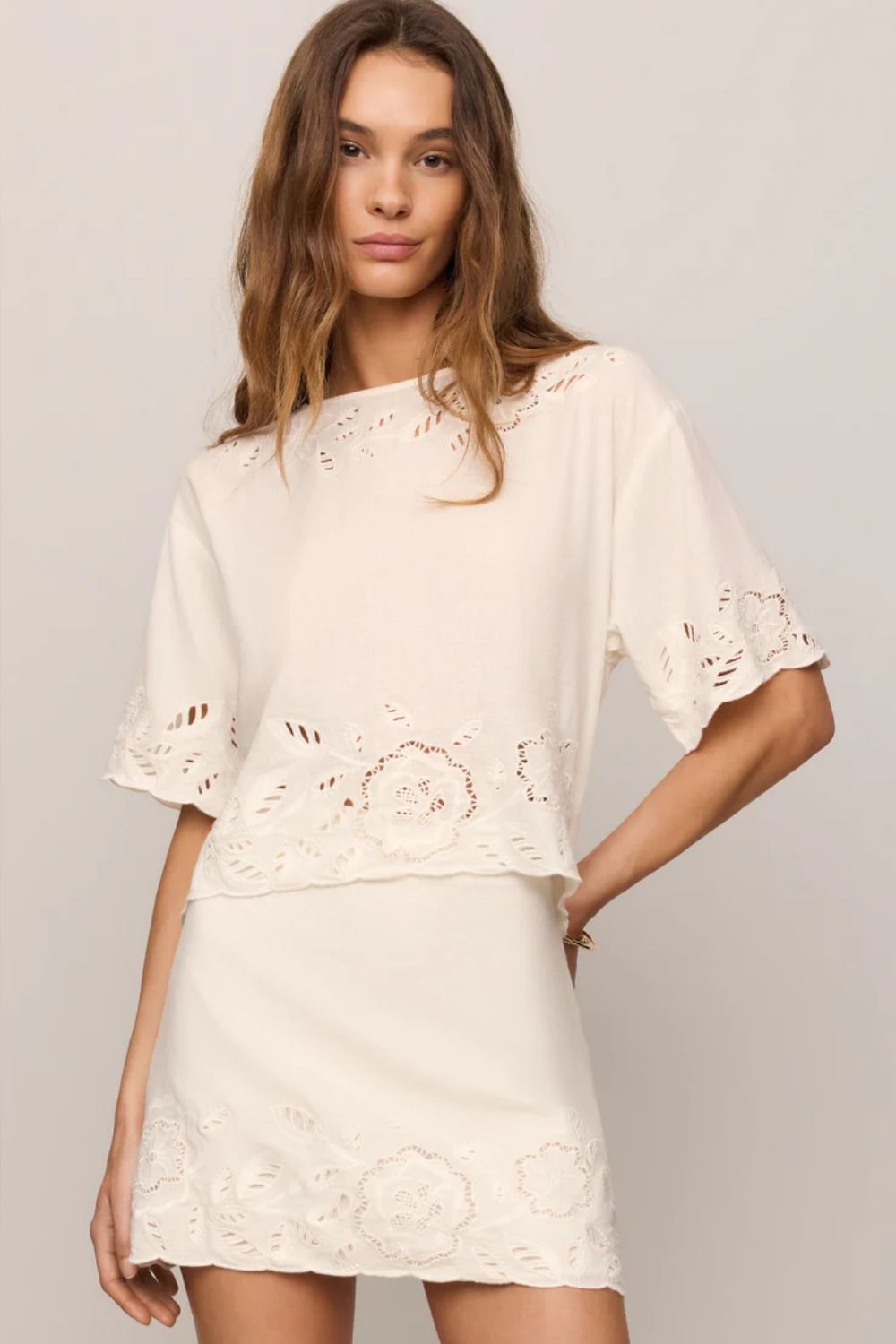 woman wearing embroidered white top on a white background 