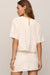 woman wearing embroidered white top on a white background 