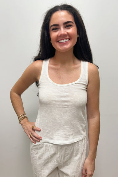 Woman wearing white tank top against gray background