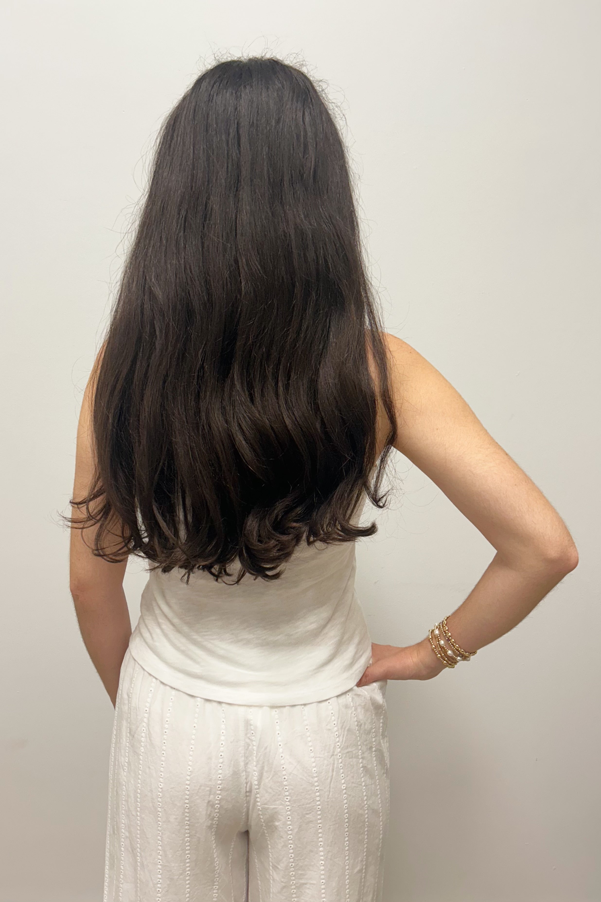 Woman wearing white tank top against gray background