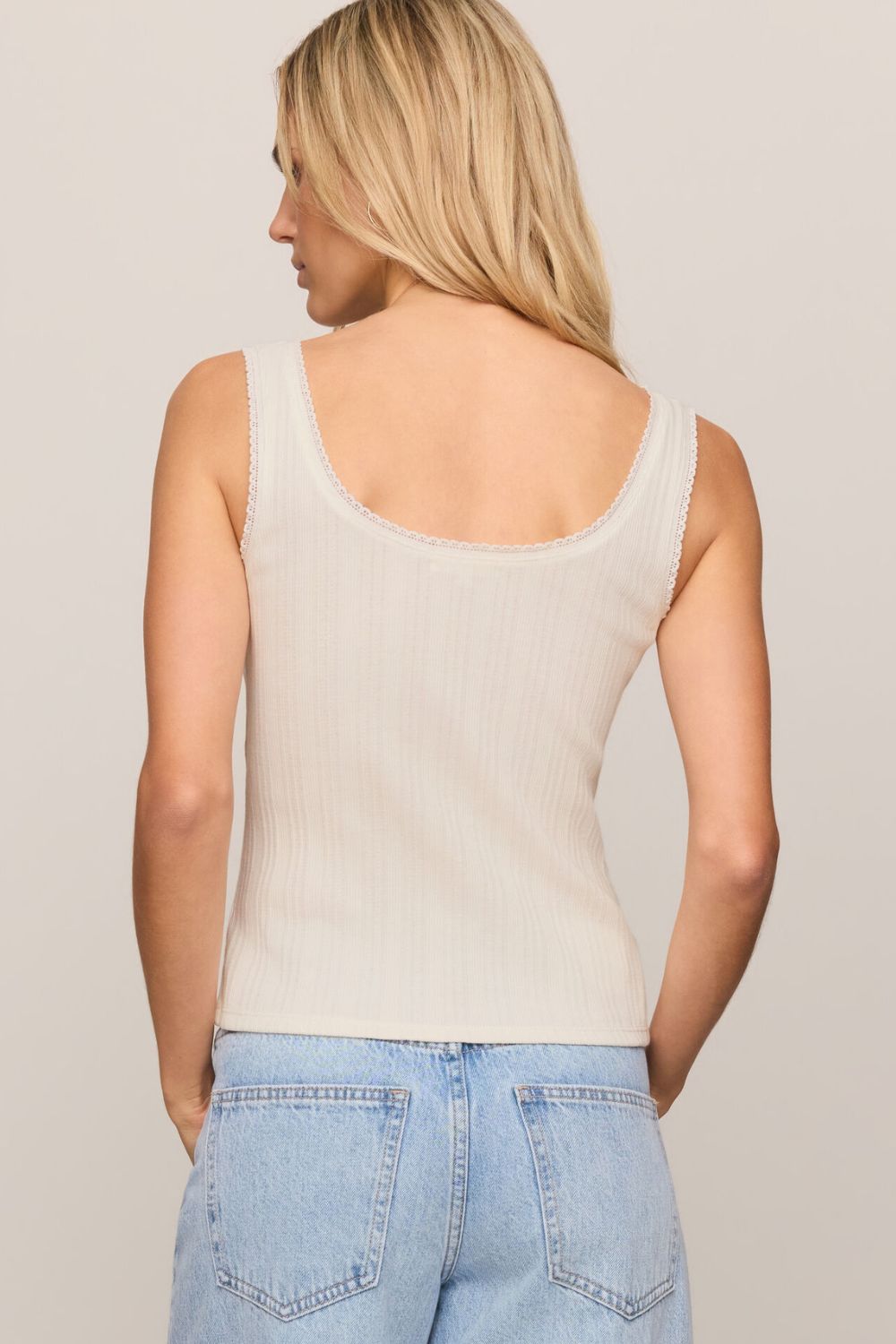 woman wearing a white tank top on a white background