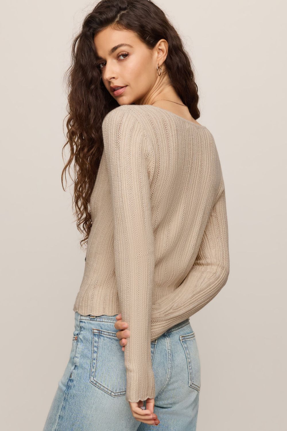 woman wearing tan button sweater with white background