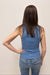 Person wearing a blue tank top and jeans from behind on a plain background