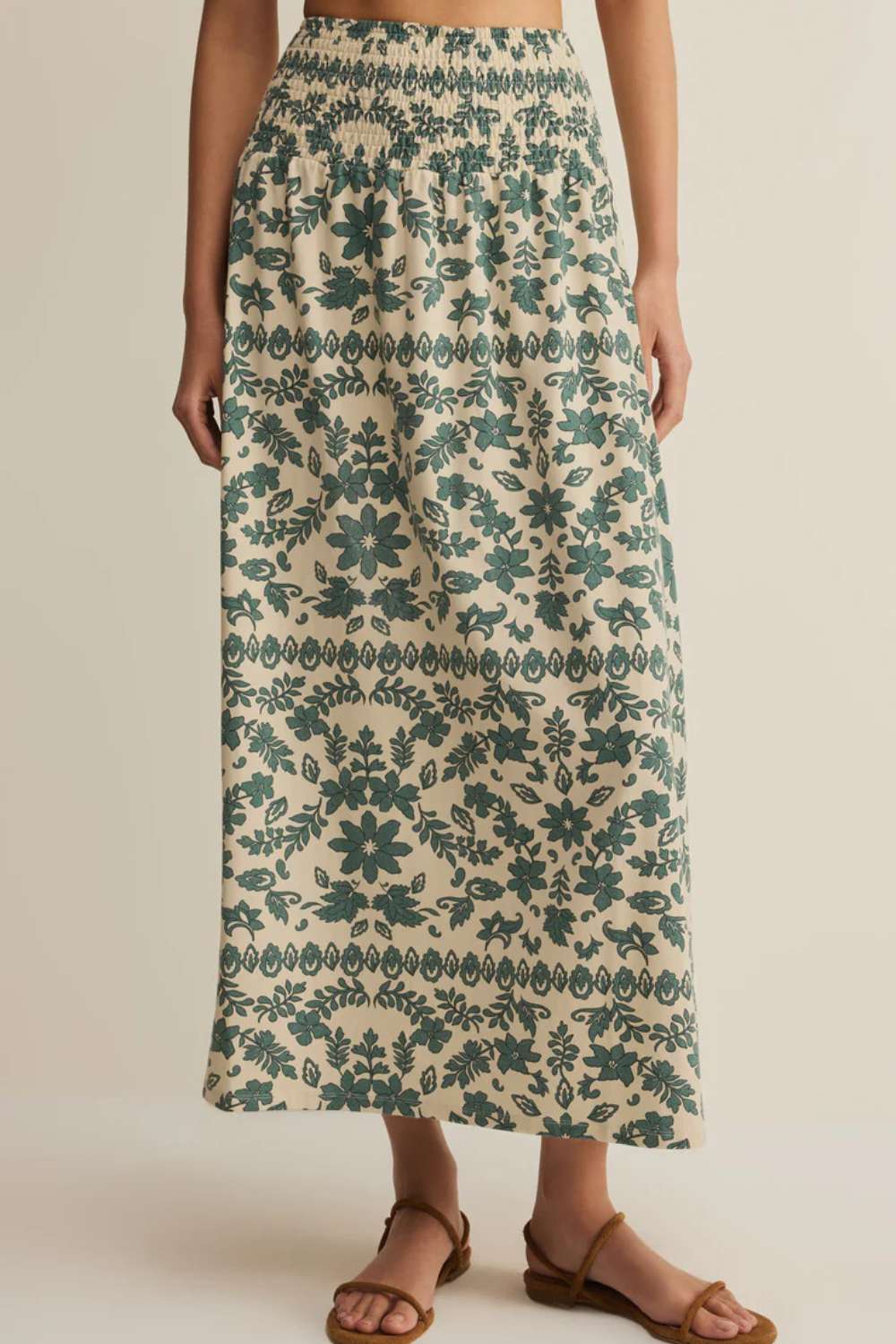 person wearing green floral patterned skirt against plain background