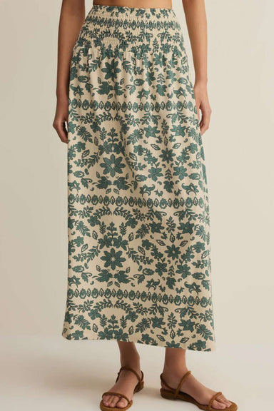 person wearing green floral patterned skirt against plain background