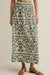 person wearing green floral patterned skirt against plain background