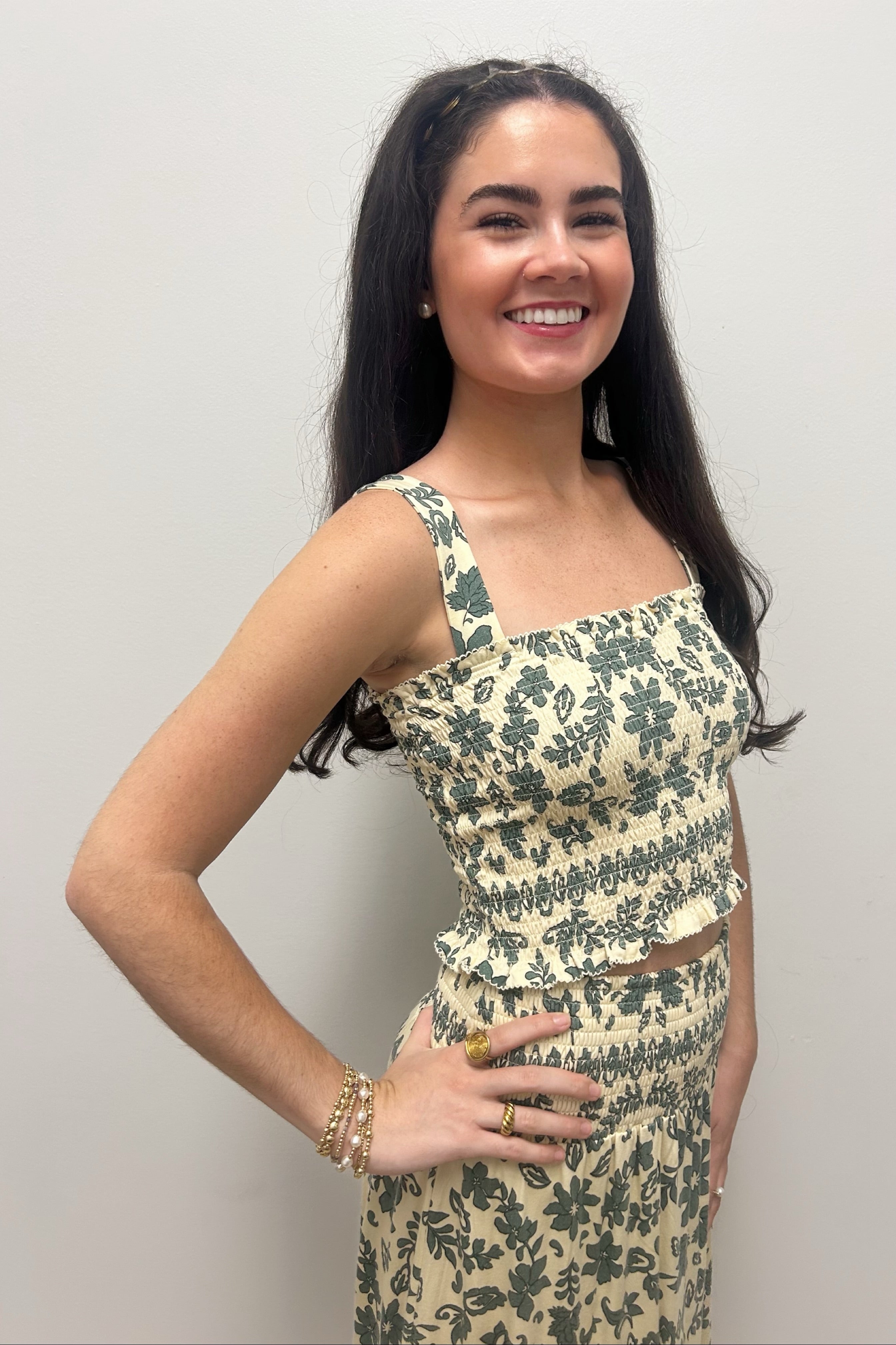 Woman wearing cream tank top with green floral detail