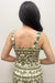 Woman wearing cream tank top with green floral detail