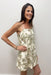 woman in cream dress with green palm tree detail