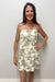 woman in cream dress with green palm tree detail