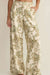 Tropical patterned pants worn by a person on a plain background